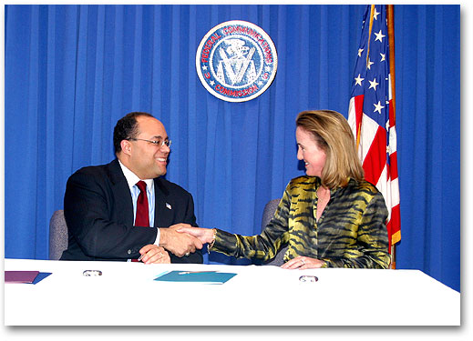 Photo of Chairman Powell and NTIA Assistant Secretary Victory Shaking Hands
