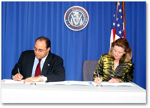Photo of Chairman Powell and NTIA Assistant Secretary Victory Signing MOU Regarding Spectrum Coordination